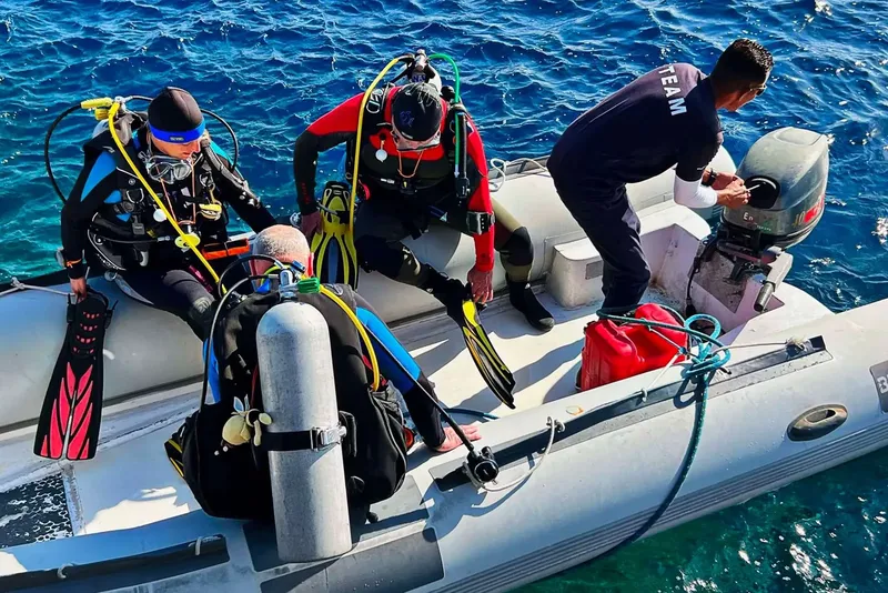 Plongeurs s'équipent sur un bateau pneumatique en mer ensoleillée