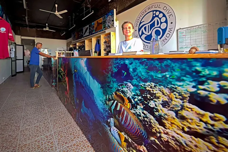 Intérieur d'un centre de plongée avec comptoir décoré et personnel accueillant