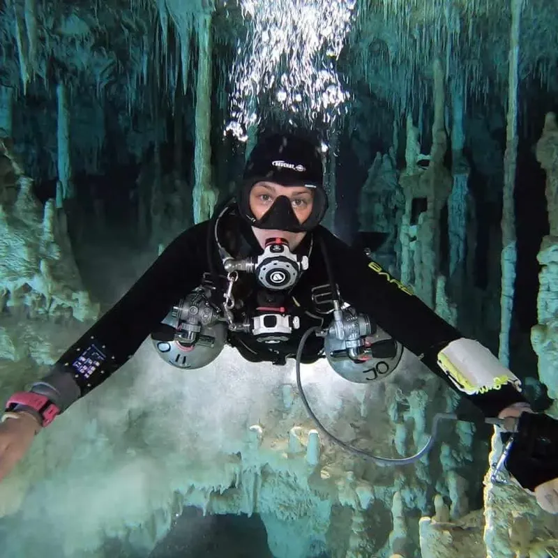 Plongeur en grotte sous-marine, équipé, explorant un environnement rocheux