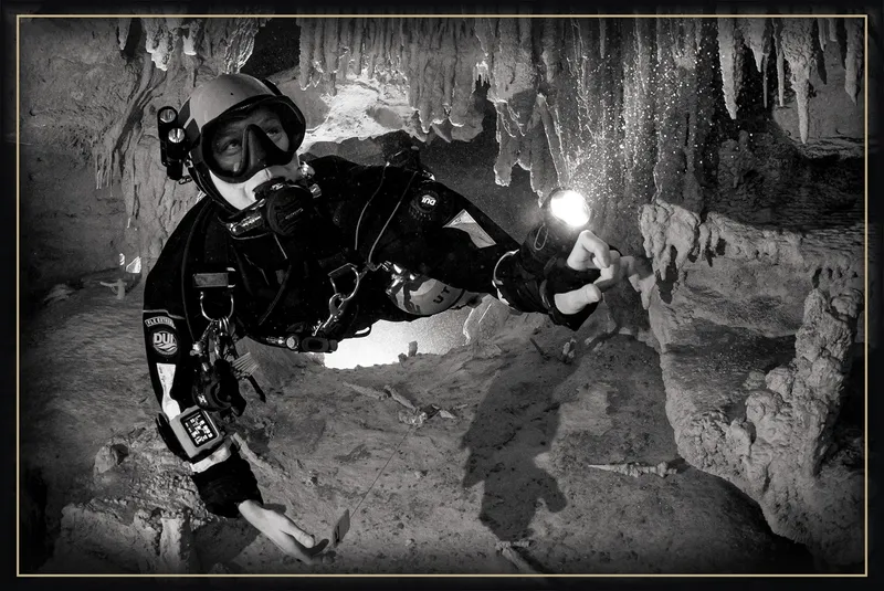 Plongeur en grotte sous-marine, éclairant les formations rocheuses calcaires