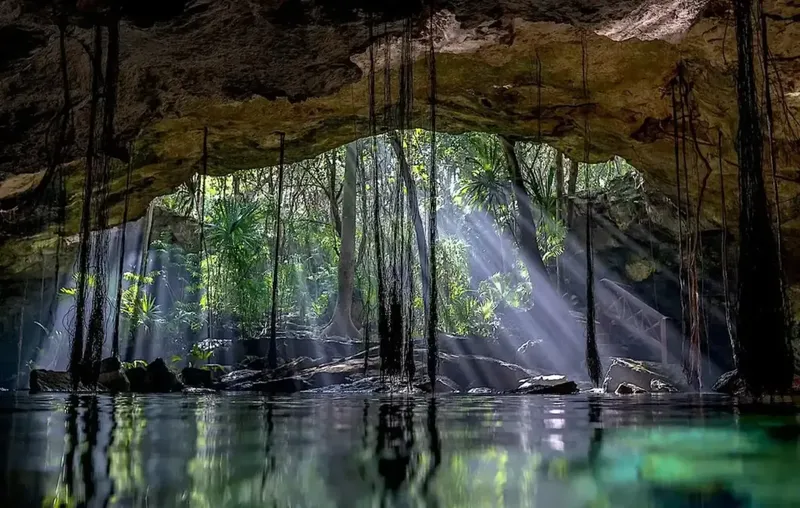 Cénote avec lumière filtrant à travers l'ouverture de la grotte