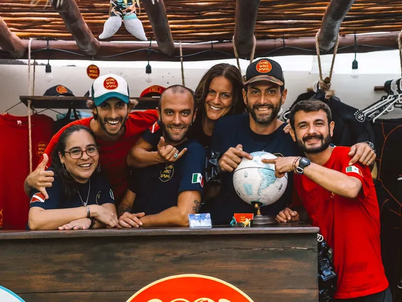 Equipe souriante derrière un comptoir avec du matériel de plongée