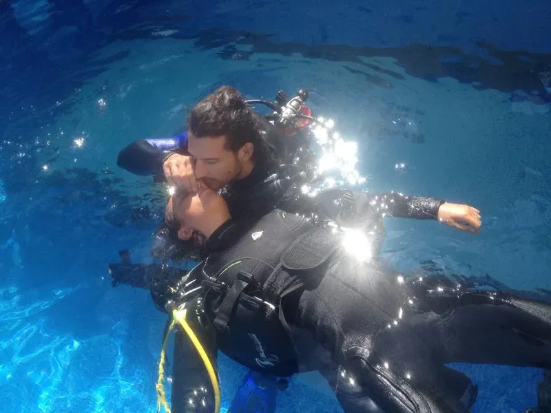 Deux plongeurs en combinaison s'entraînent dans une piscine claire