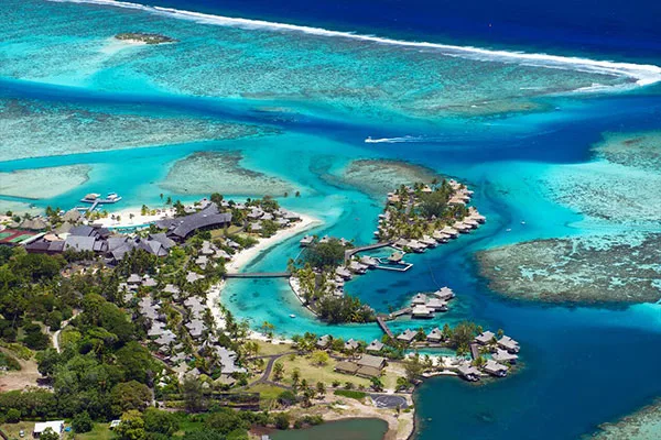Vue aérienne d'un complexe hôtelier avec des bungalows sur pilotis