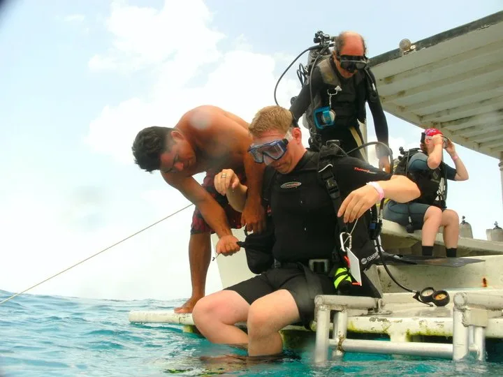 Préparation d'un plongeur par un moniteur sur un bateau en mer