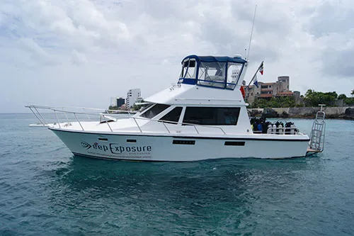 Bateau de plongée blanc et bleu sur l'eau calme et turquoise