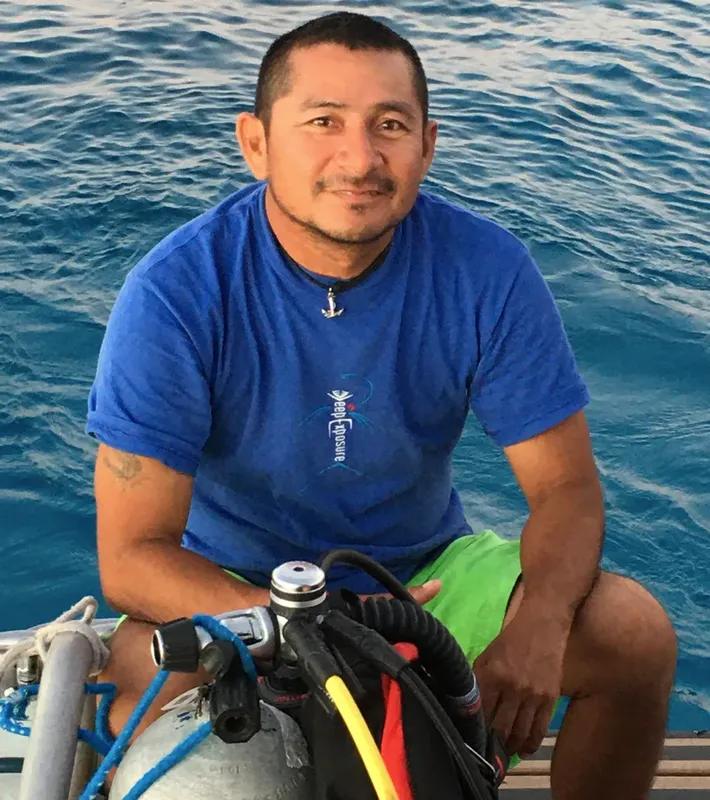 Plongeur souriant sur un bateau avec son équipement de plongée