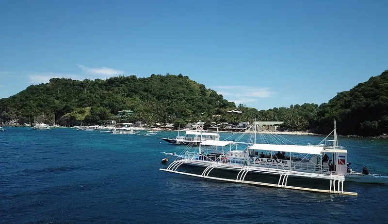 Plusieurs bateaux de plongée amarrés dans une baie tropicale ensoleillée