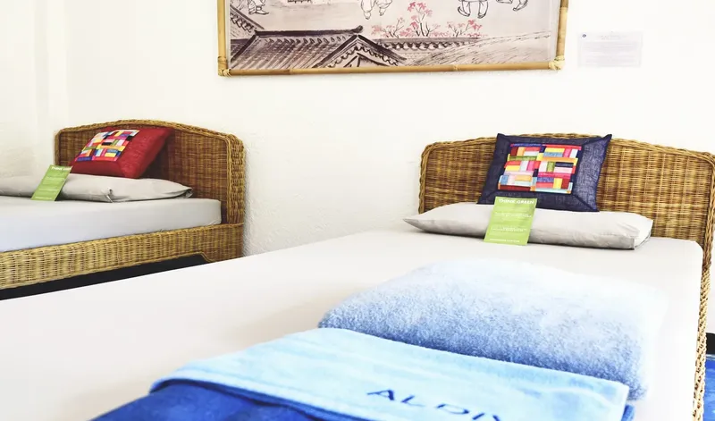 Deux lits simples avec oreillers et coussins dans une chambre claire
