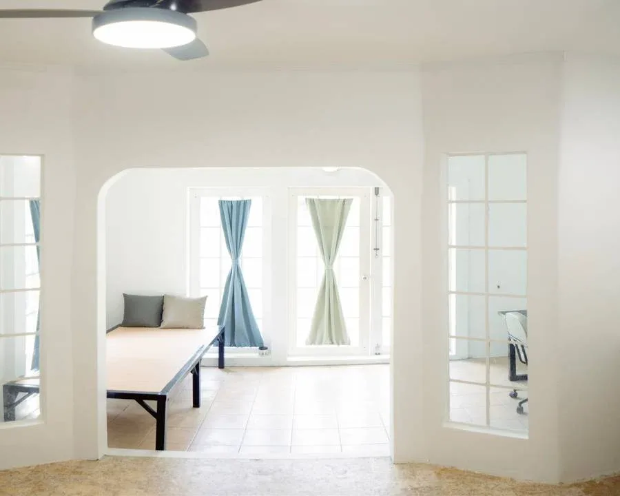Interieur clair avec banc, fenetres et rideaux bleus, ambiance reposante