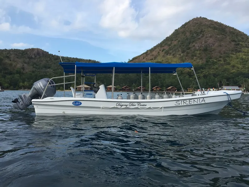 Bateau de plongée blanc avec plusieurs bouteilles à bord sur l'eau