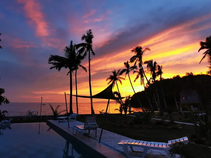 Coucher de soleil sur la mer avec palmiers et espace détente
