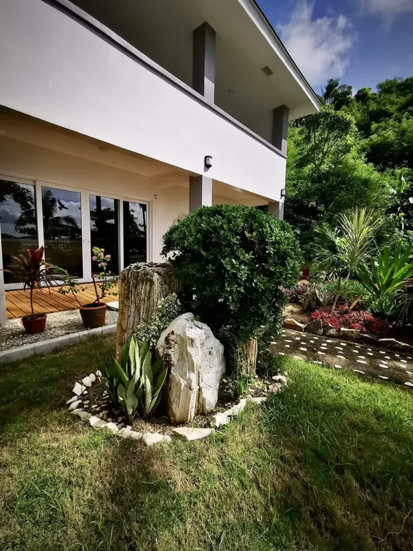 Façade d'un bâtiment moderne avec jardin tropical et végétation luxuriante