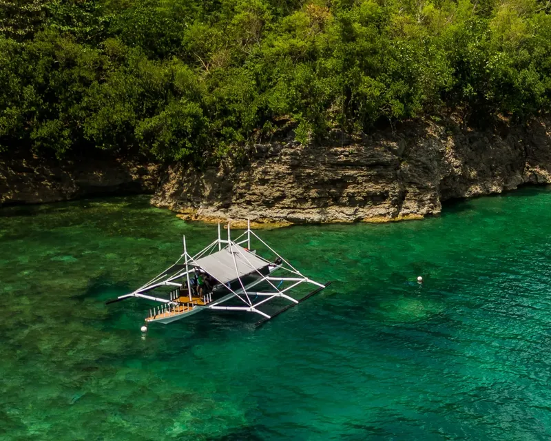Bateau de pêche traditionnel sur une eau turquoise et claire
