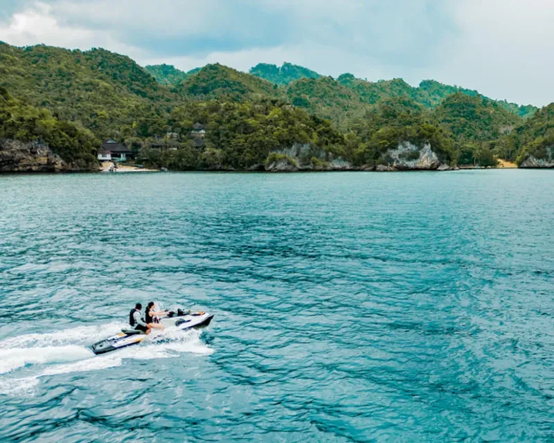 Deux personnes sur un jet ski naviguent sur une mer turquoise