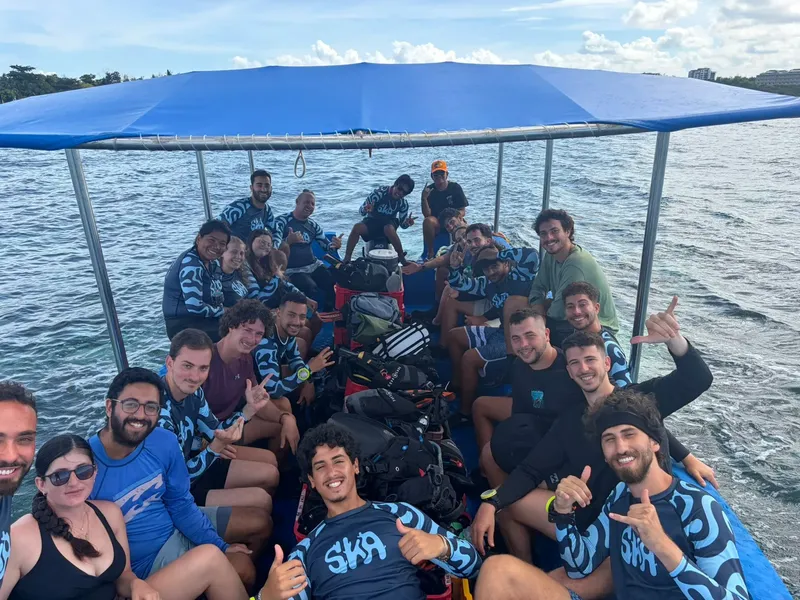 Groupe de plongeurs souriants à bord d'un bateau en mer