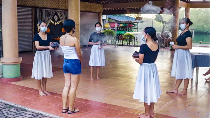 Cinq femmes en tenue traditionnelle effectuent un rituel avec de l'encens