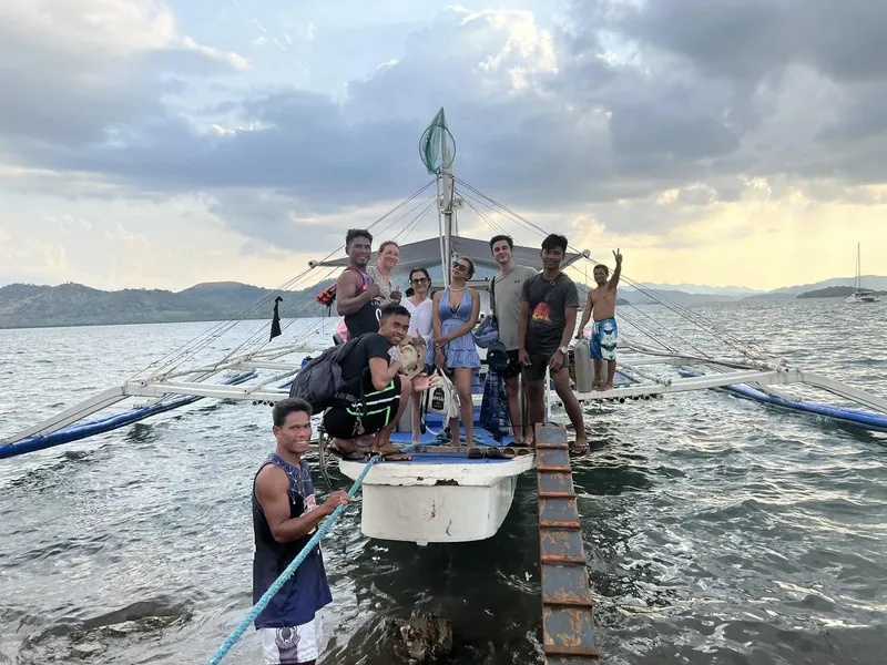 Groupe de personnes souriantes sur un bateau traditionnel en mer