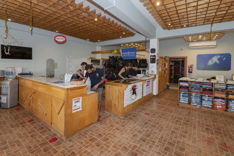 Intérieur d'un centre de plongée avec comptoir d'accueil et équipement
