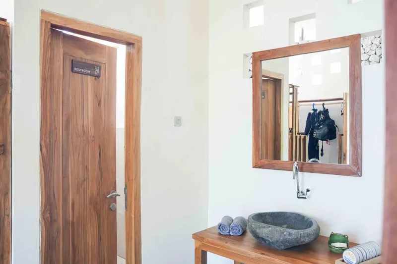 Intérieur d'une salle de bain avec lavabo, miroir et porte