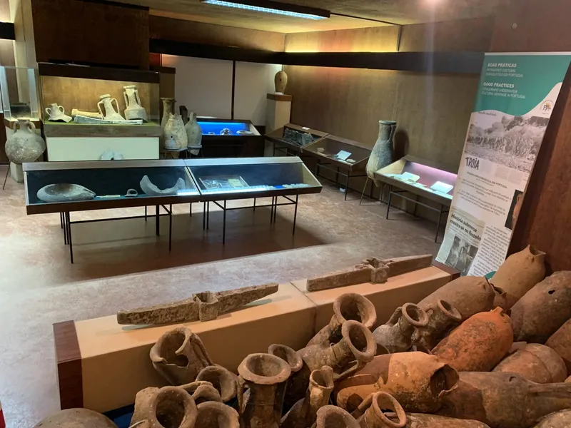 Salle d'exposition avec amphores anciennes et panneaux d'information sur l'archéologie
