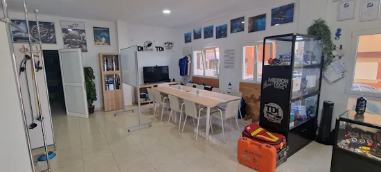 Salle d'attente d'un centre de plongée avec équipement et photos