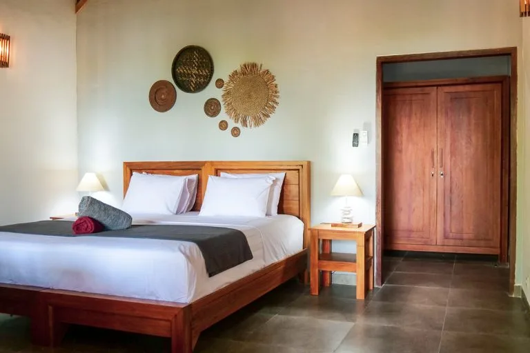 Chambre d'hôtel avec lit double, décoration murale et mobilier en bois