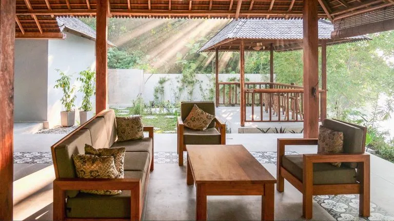 Espace détente extérieur avec mobilier en bois et végétation luxuriante