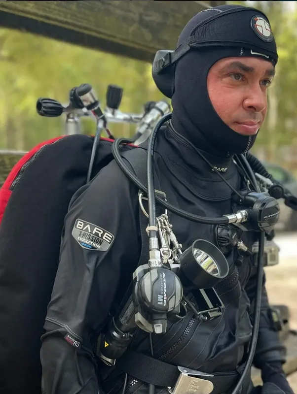 Plongeur équipé d'une combinaison noire et d'un masque regarde vers l'avant