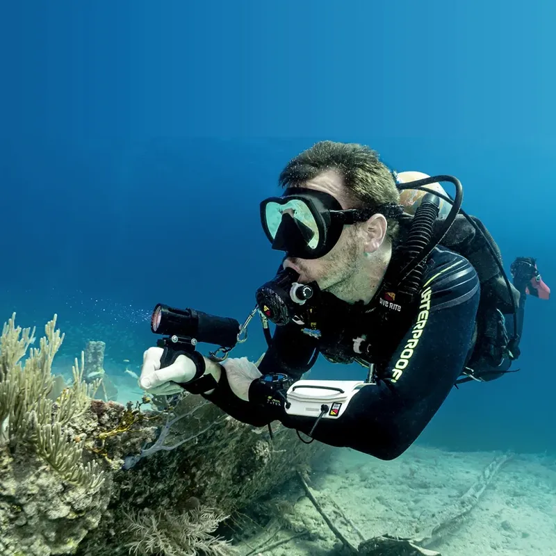 Plongeur avec appareil photo sous-marin, exploration des fonds marins bleus