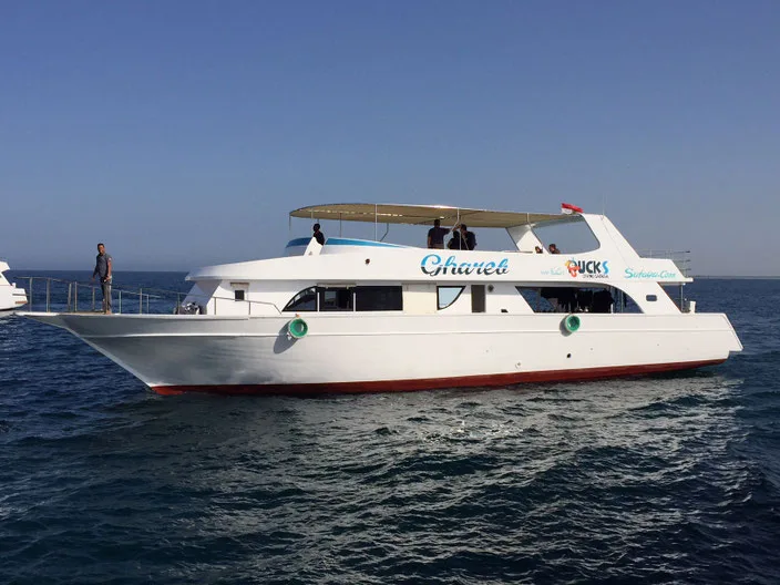 Bateau de plongée blanc naviguant sur une mer bleue calme