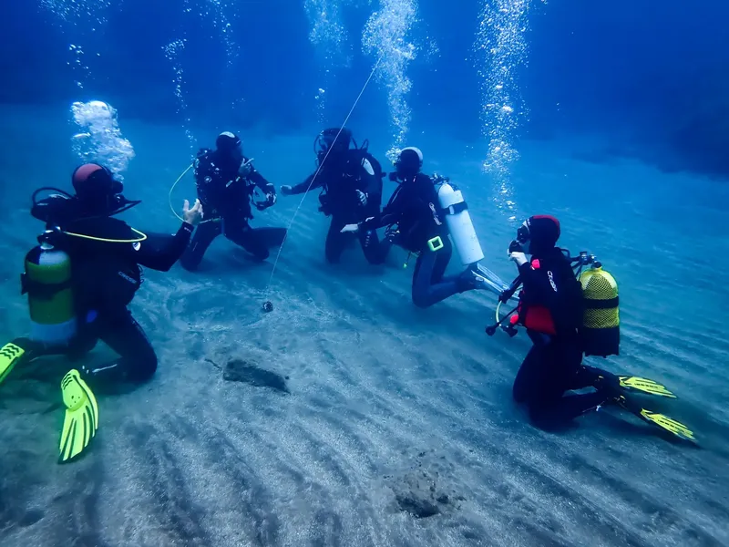 Groupe de plongeurs sous-marin, formation ou exploration, eau claire