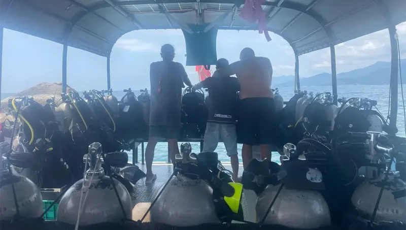 Intérieur d'un bateau de plongée rempli de bouteilles et de plongeurs