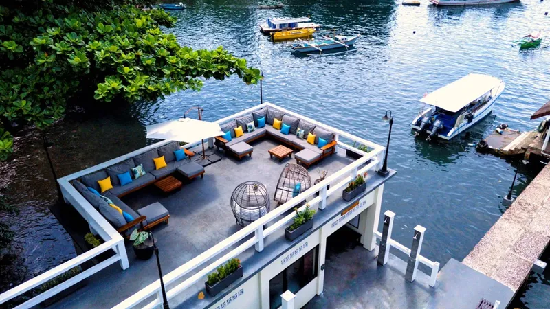 Terrasse aménagée sur l'eau avec mobilier, bateaux et végétation luxuriante