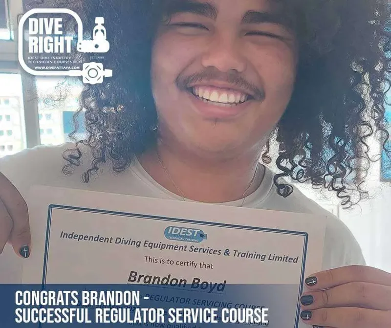 Un homme souriant tient un certificat de cours de maintenance de detendeur