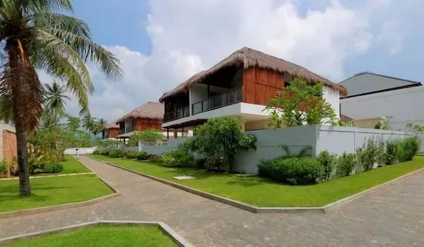 Bâtiments modernes avec toits de chaume et végétation tropicale luxuriante