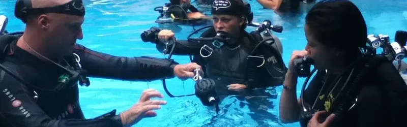 Formation plongée en piscine, instructeur vérifiant l'équipement d'un élève