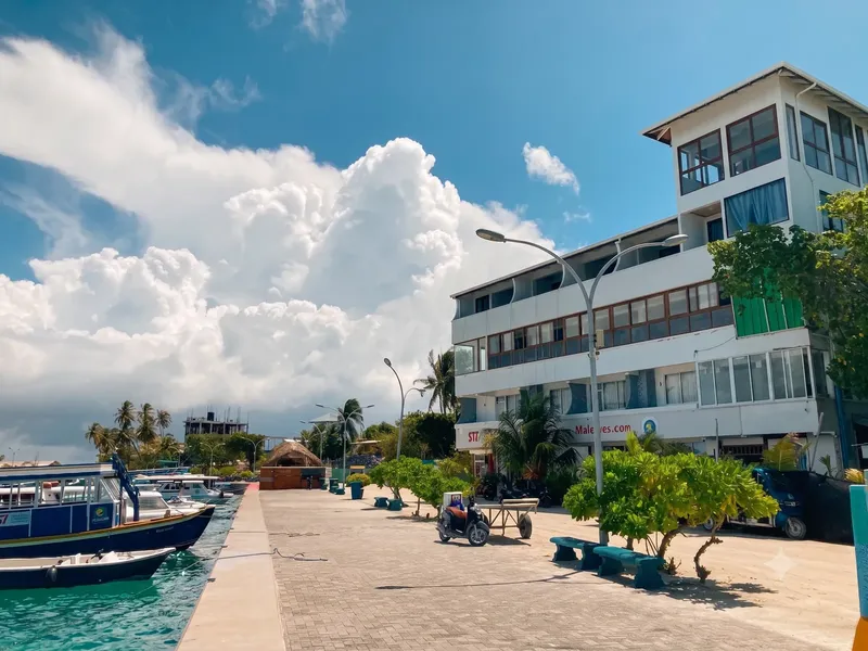 Bateaux amarrés devant un bâtiment blanc avec végétation tropicale