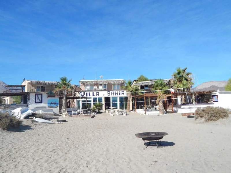 Bâtiment sur plage de sable avec palmiers et enseigne Villa Bahia