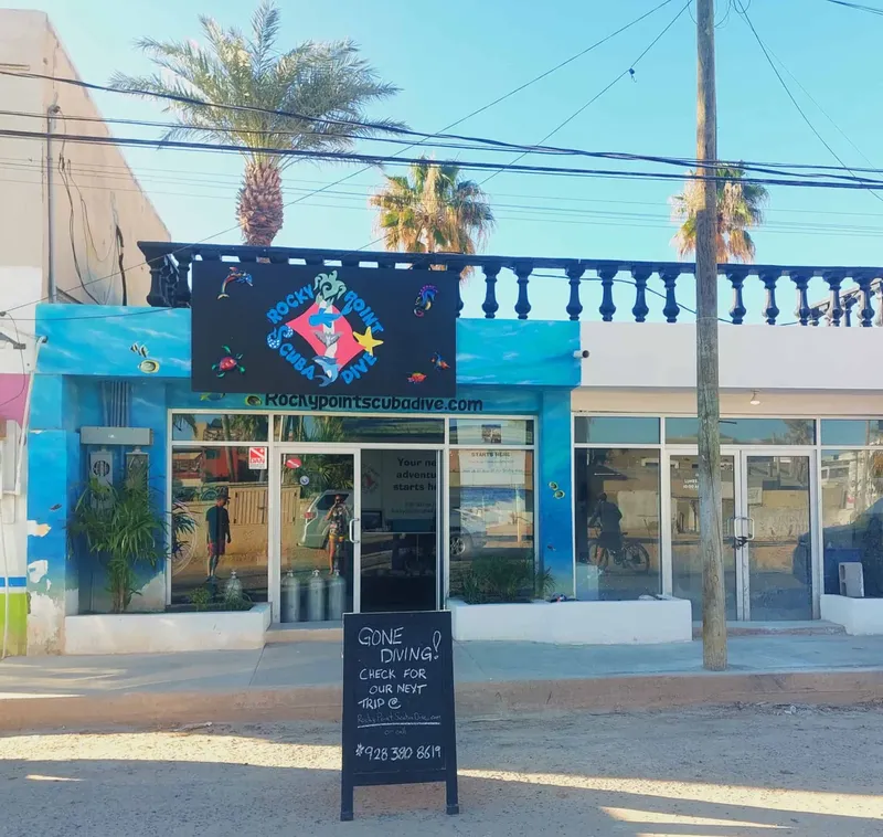 Façade d'un centre de plongée avec des bouteilles et des personnes