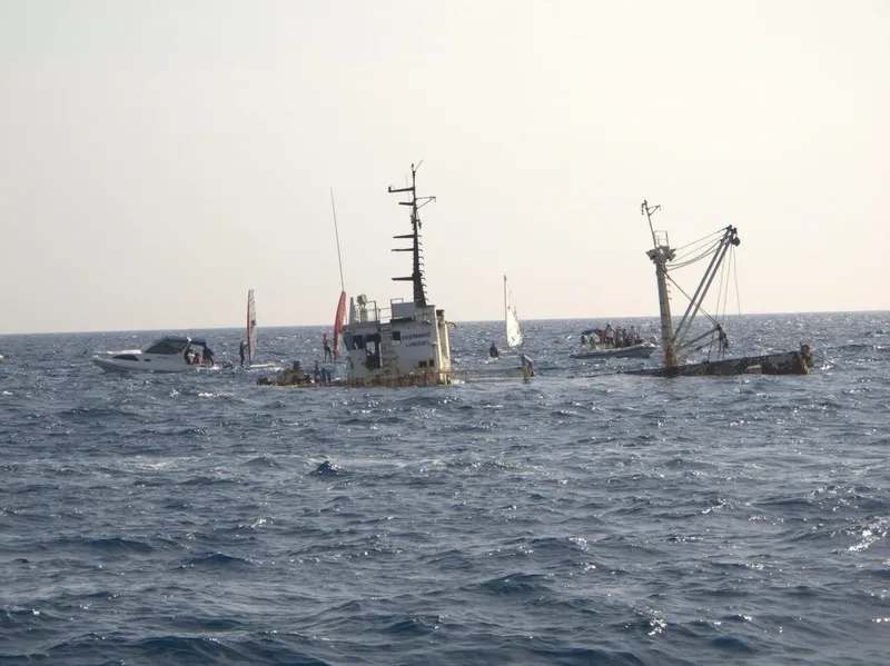 Plongeurs autour d'épaves de bateaux en mer, ciel clair