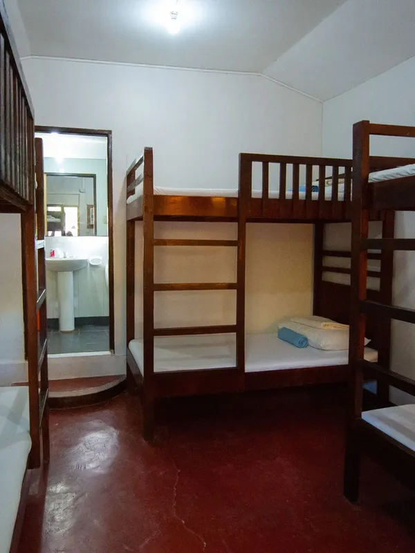Dortoir avec lits superposés et salle de bain visible en fond