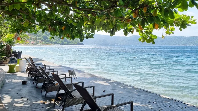 Terrasse en bois avec transats, vue sur la mer et montagnes