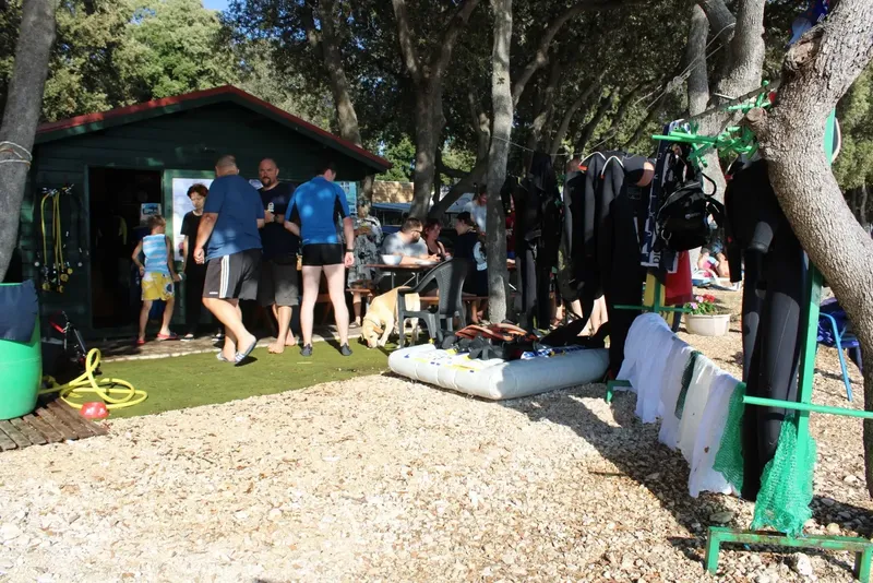 Groupe de personnes près d'un bâtiment et d'équipements de plongée