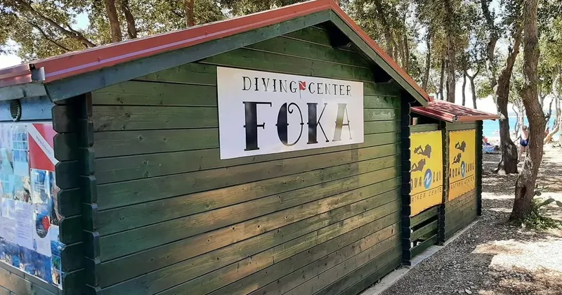 Façade d'un centre de plongée en bois vert avec son enseigne