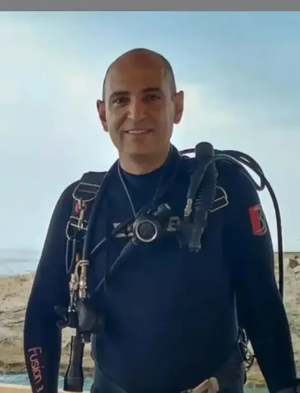 Plongeur souriant en combinaison, équipé de son matériel de plongée