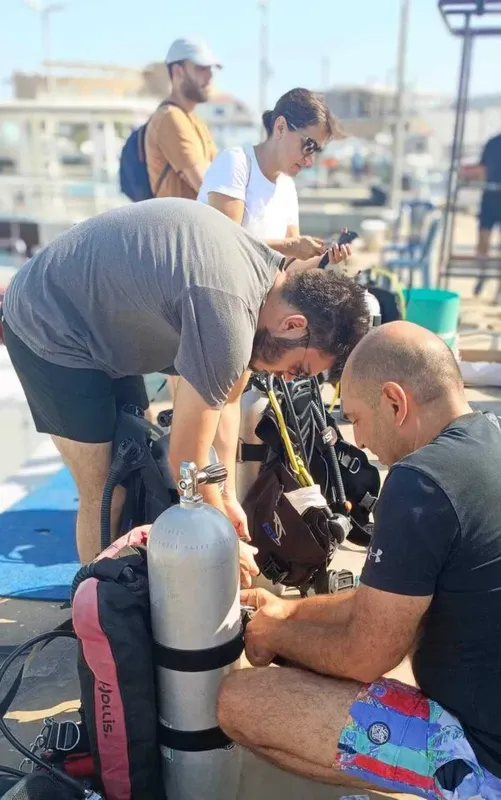 Préparation du matériel de plongée avec des personnes sur un quai