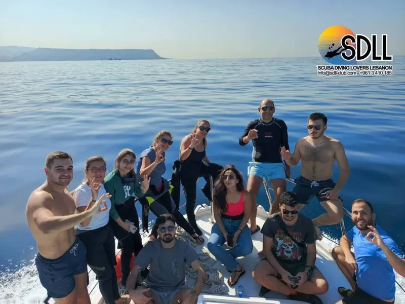 Groupe de plongeurs souriants à bord d'un bateau en mer