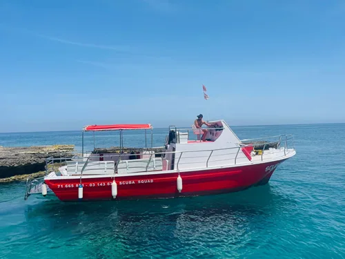 Bateau de plongée rouge et blanc sur une mer turquoise ensoleillée