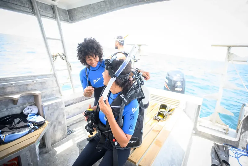 Deux plongeuses s'équipent sur un bateau en préparation d'une plongée